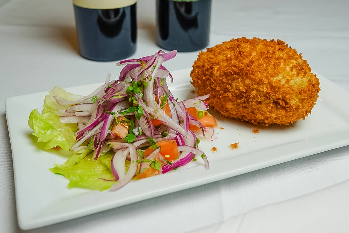 A plate of food with salad and a fried meat.