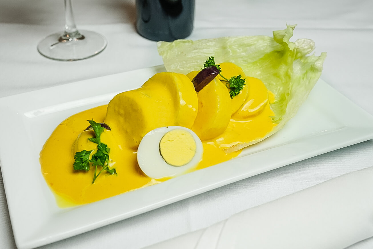 A plate of food with yellow sauce and an egg.