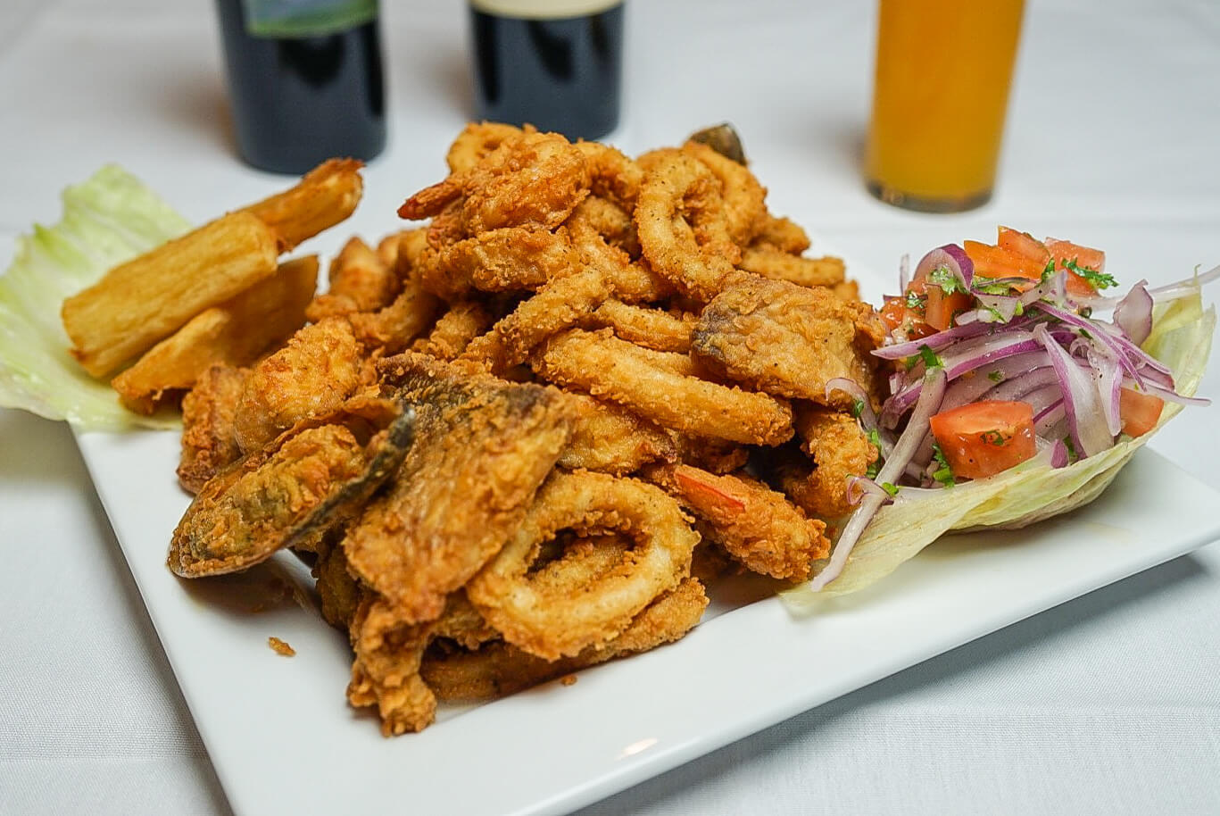 A plate of fried food with fries and coleslaw.