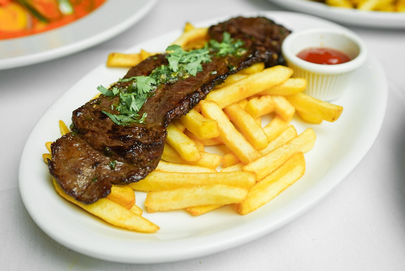 A plate of food with fries and steak.