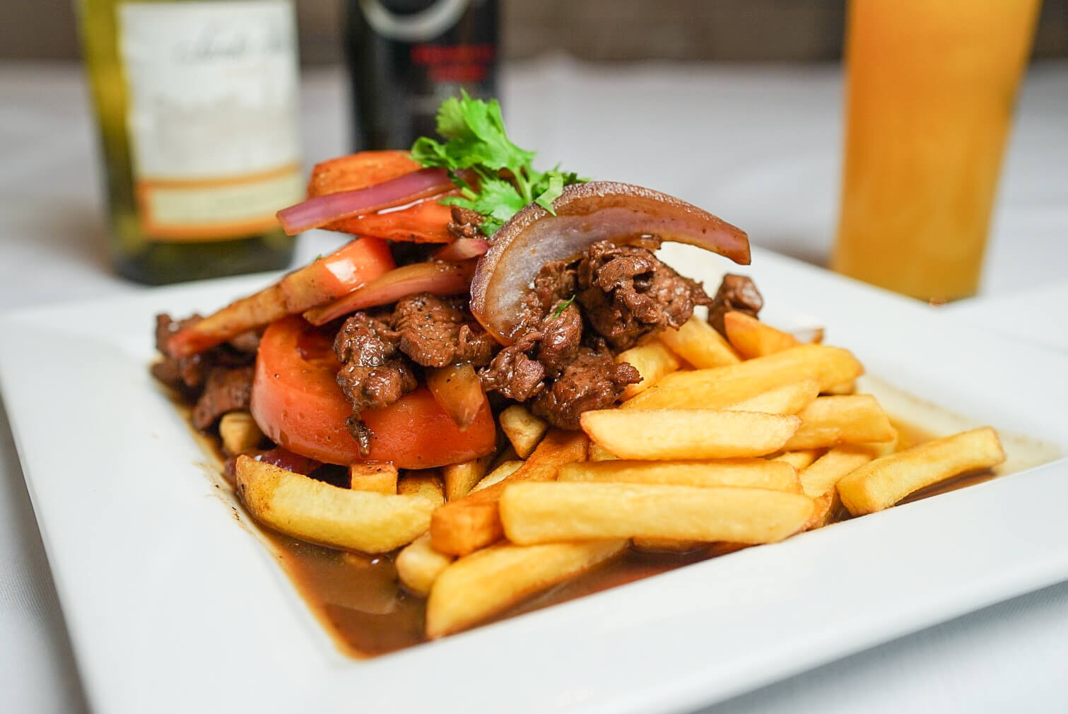 A plate of food with fries and meat on it.