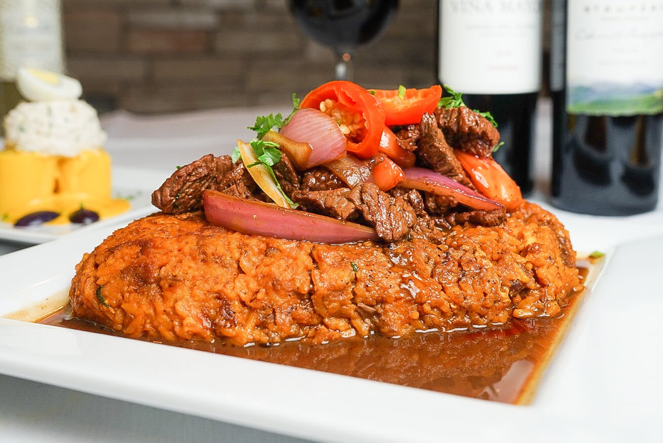 A plate of food with meat and vegetables on top.