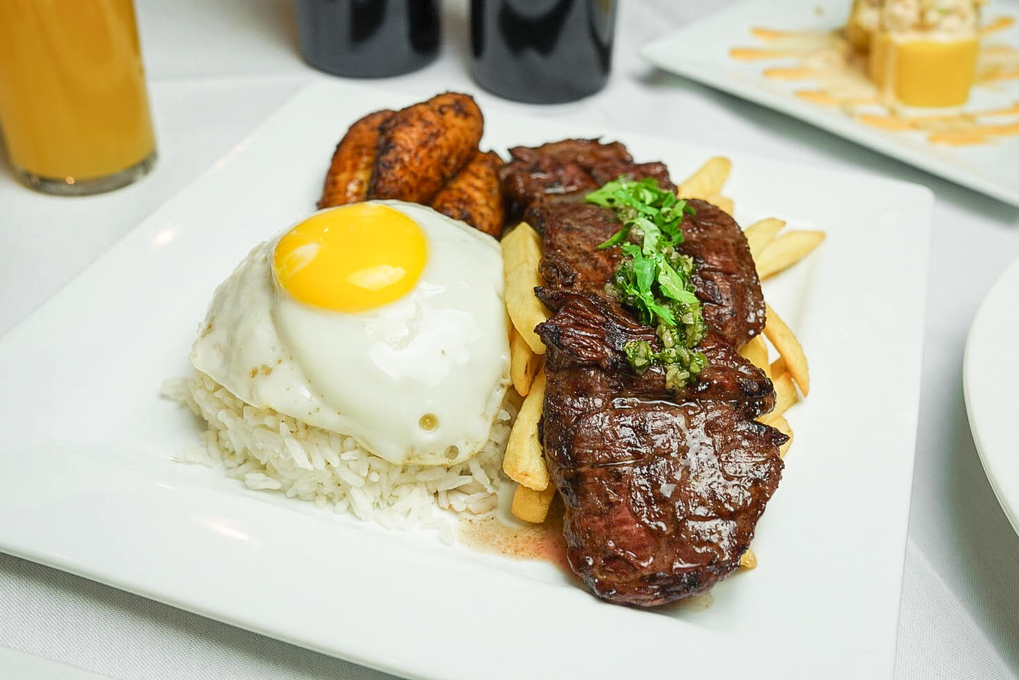 A plate of food with steak, fries and an egg.