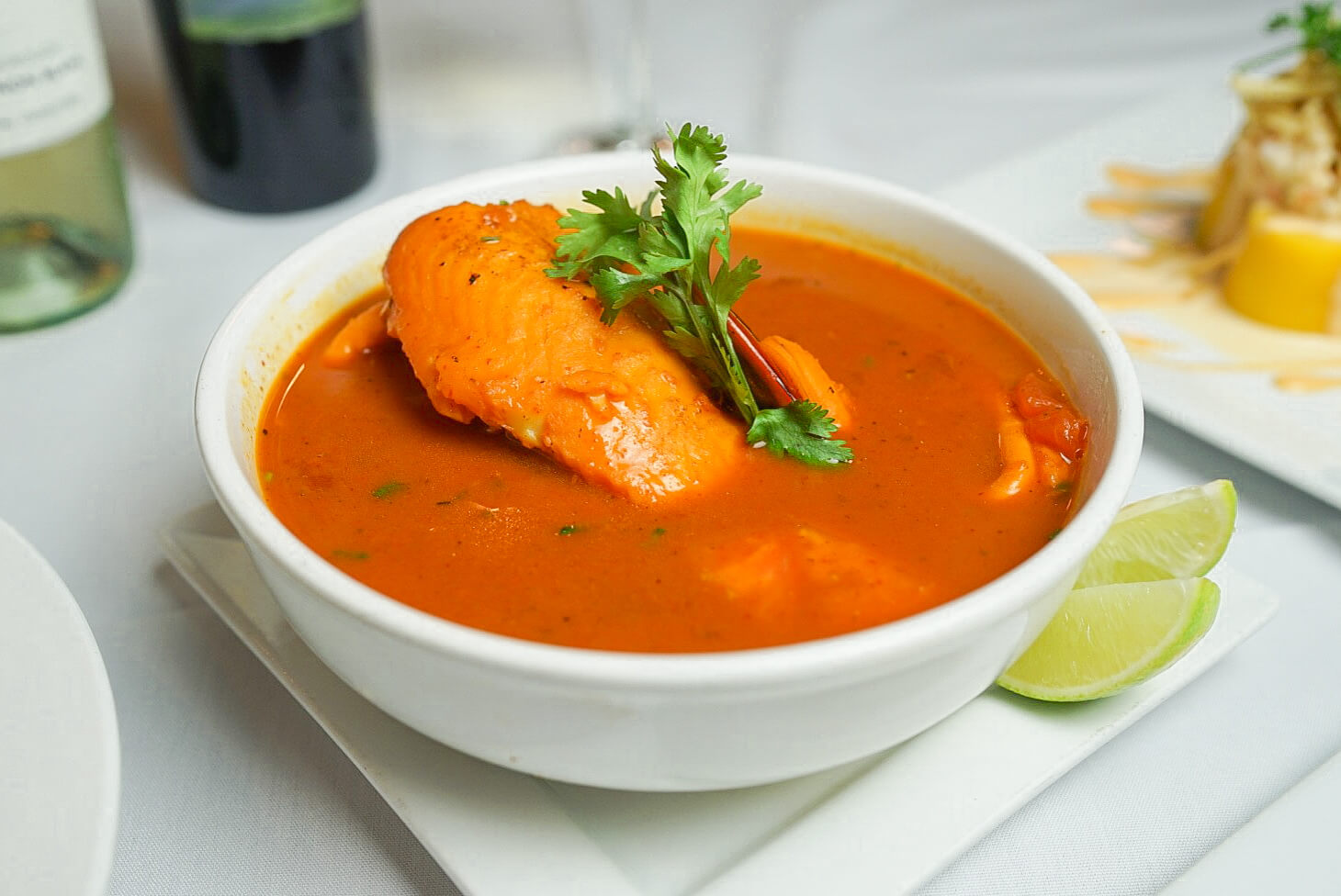 A bowl of soup with chicken and cilantro.