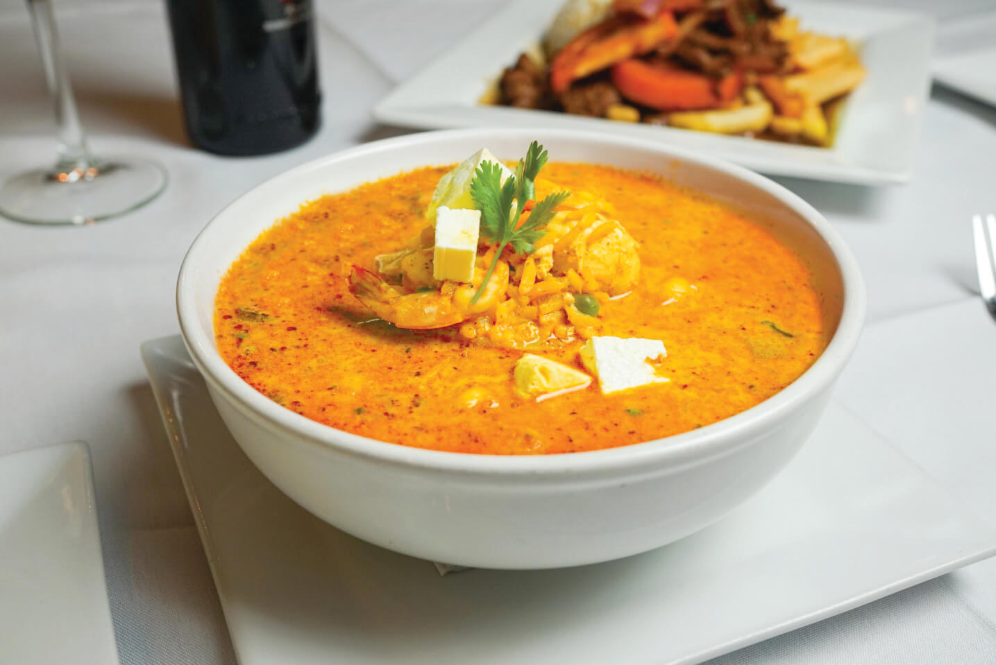 A bowl of soup with meat and vegetables.